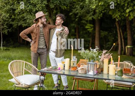 Zwei männliche Freunde sprechen während eines Mittagessens in der Natur Stockfoto