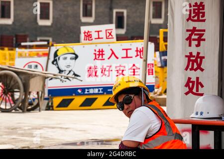 Eine Bauarbeiterin auf einer Baustelle an der Moganshan Road in der Nähe der M50 in Shanghai, China. Stockfoto