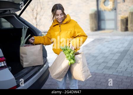 Frau kommt mit Einkäufen nach Hause Stockfoto