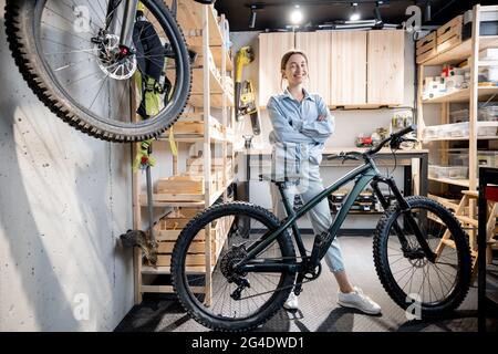 Handywoman mit einem Fahrrad in der Werkstatt Stockfoto