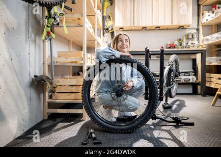 Handywoman mit ihrem Fahrrad in der Werkstatt Stockfoto