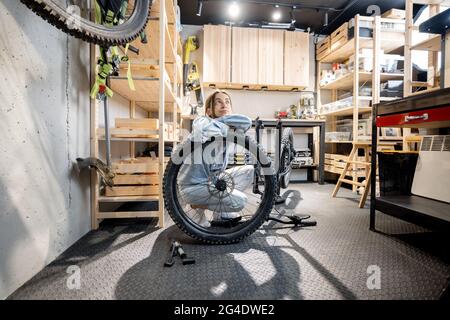 Handywoman mit ihrem Fahrrad in der Werkstatt Stockfoto