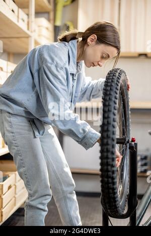 Handywoman repariert Fahrrad in der Werkstatt Stockfoto