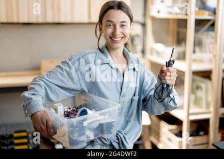 Frau mit Arbeitswerkzeugen in der Hauswerkstatt Stockfoto