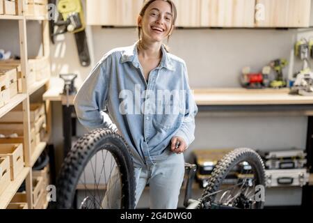 Handywoman repariert Fahrrad in der Werkstatt Stockfoto