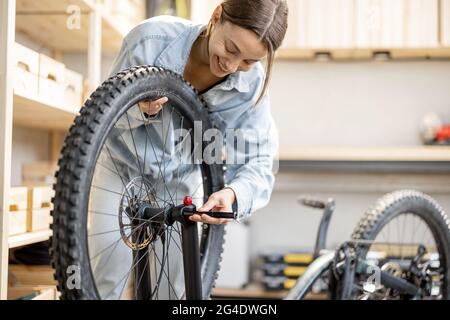 Handywoman repariert Fahrrad in der Werkstatt Stockfoto