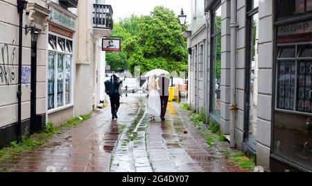 Brighton UK 21. Juni 2021 - EINE Braut und ein Bräutigam lassen sich heute in Brighton nicht vom Sommersonnenwende-Regen verwöhnen : Credit Simon Dack / Alamy Live News Stockfoto