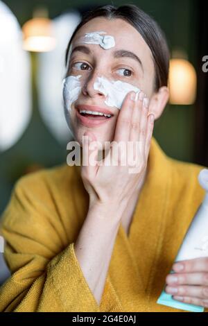 Frau trägt eine Creme oder Peeling-Maske auf das Gesicht Stockfoto