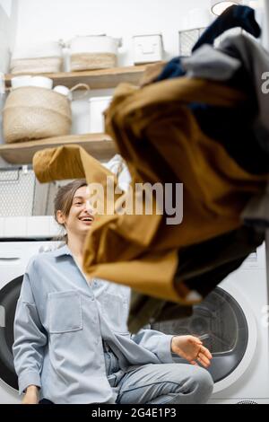 Hausfrau wirft Kleidung an der Wäscherei Stockfoto