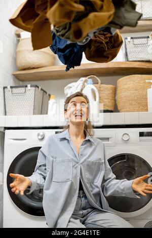 Hausfrau wirft Kleidung an der Wäscherei Stockfoto