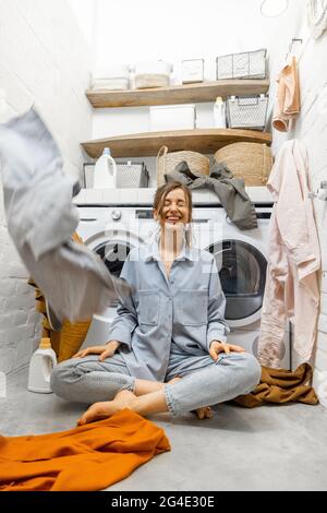 Hausfrau wirft Kleidung an der Wäscherei Stockfoto