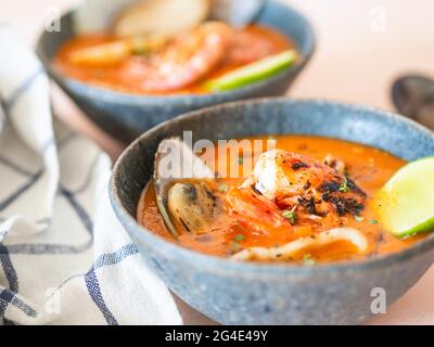 Tomatensuppe mit Meeresfrüchten in blauen Keramikschalen. Mediterrane Küche. Nahaufnahme. Selektiver Fokus. Stockfoto