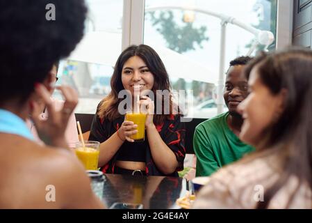 Lifestyle- und Freundschaftskonzepte mit echten Menschenmodellen. Multinationale Freunde unterhalten sich in einem Café. Das Ende der Pandemie Stockfoto