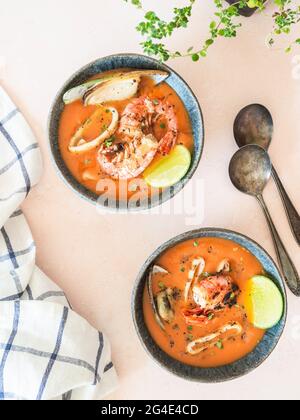 Tomatensuppe mit Meeresfrüchten in blauen Keramikschalen. Mediterrane Küche. Nahaufnahme. Draufsicht Stockfoto