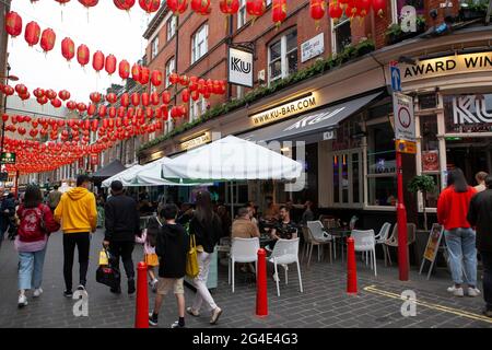 London, Großbritannien, 20. Juni 2021: Die Straßen von Chinatown sind voller Kunden und trotz des bewölkten Wetters bevorzugen viele Menschen es, draußen zu essen. Anna Watson/Alamy Stockfoto