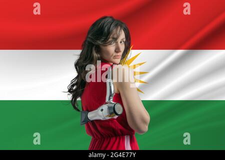 Schönheitsindustrie in Kurdistan. Glückliche weibliche Friseur hält Haartrockner vor Kurdistan Flagge Hintergrund. Stockfoto