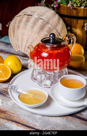 Roter Beerentee in einem durchsichtigen Glaskessel mit einer Tasse Tee. Stockfoto
