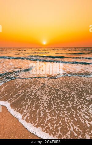 Sonnenuntergang Sonne Über Meer. Natürlicher Sonnenaufgang Himmel Warme Farben Über Dem Wellenmeer. Ocean Water Schaum Waschen Sandstrand Bei Sonnenuntergang Stockfoto