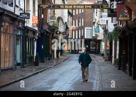 Ein älterer Mann mit Gesichtsmaske geht am 6. Januar 2021, dem Tag daran, durch die leere Einkaufsstraße von Stonegate im Stadtzentrum von York im Norden von Yorkshire Stockfoto