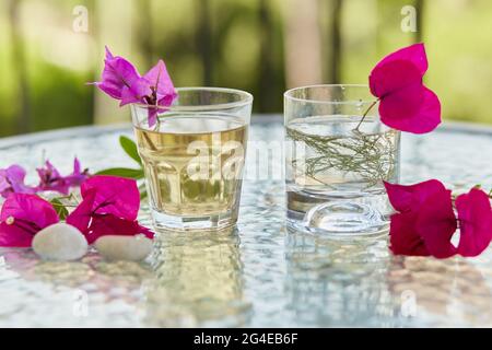 Im Sommer werden hausgemachte Cocktails aus der Nähe serviert und rosa Blumen mit Bougainvillea-Dekorationen und pubbles. Sommertapete. Stockfoto