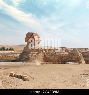 Die ikonische Sphinx-Schnitzerei neben den Großen Pyramiden in Gizeh, Ägypten. Die große alte Sphinx auf blauem Hintergrund. Stockfoto