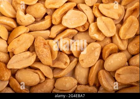 Geröstete gesalzene Erdnüsse, Oberflächenstruktur. Nahaufnahme, selektiver Fokus. Ein beliebter Snack für Bier. Stockfoto