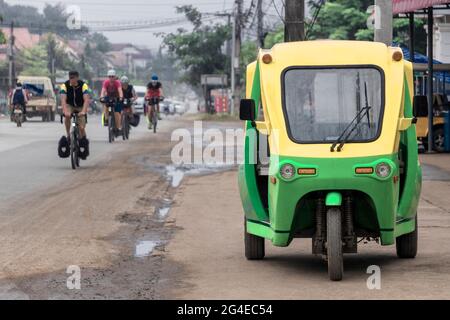 Grün und gelb umweltfreundliche elektronische Tuk Tuk Fahrzeug Auto Rikscha in Luang Prabang Laos Asien. Stockfoto