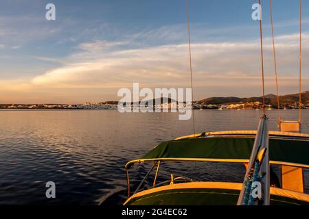Rosa Sonnenaufgang über dem Meer und Naoussa Küstendorf Paros Island, Landschaftsansicht vom Segelboot mit Bootsandach im Vordergrund, Griechenland. Stockfoto