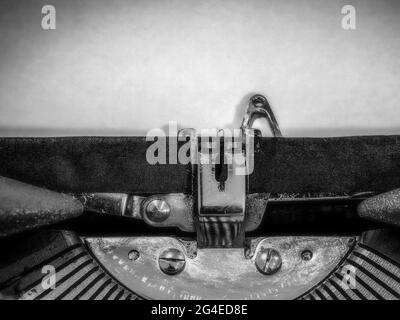 Nahaufnahme der Schreibmaschine mit einem leeren Blatt Papier in Schwarzweiß Stockfoto