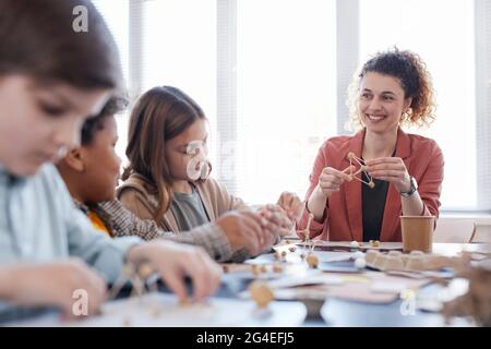 Porträt einer lächelnden Lehrerin mit einer Gruppe von Kindern, die in der Schule Kunst- und Handwerksklasse genießen, Kopierraum Stockfoto