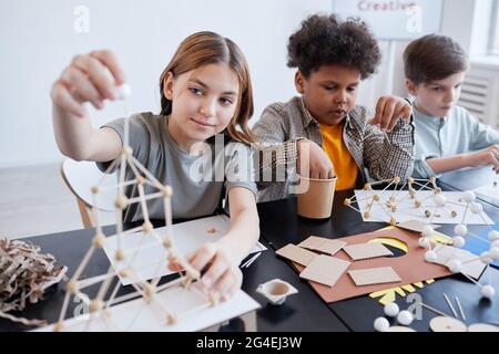 Diverse Gruppe von Kindern, die während des Kunst- und Handwerkskurens in der Schule Holzmodelle basteln, Kopierraum Stockfoto
