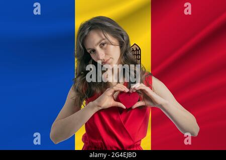 Ich Liebe Moldawien. Ein Mädchen hält vor dem Hintergrund der Flagge Moldawiens ein Herz auf ihrer Brust in den Händen. Der Begriff des Patriotismus. Stockfoto