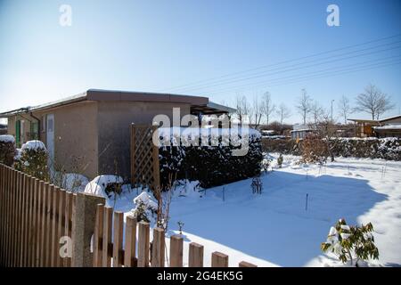 Im Winter ruht ein kleiner schneebedeckter Schottergarten Stockfoto