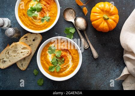 Kürbissuppe serviert mit Rahm und Koriander Stockfoto