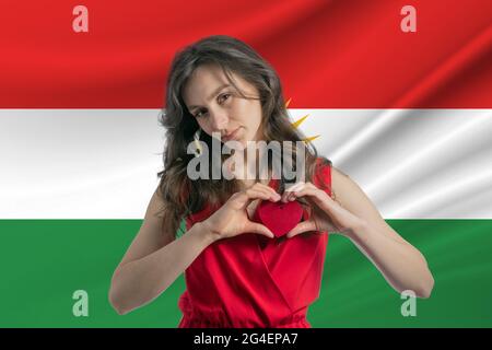 Ich Liebe Kurdistan. Ein Mädchen hält vor dem Hintergrund der Flagge Kurdistans ein Herz auf ihrer Brust in den Händen. Der Begriff des Patriotismus. Stockfoto