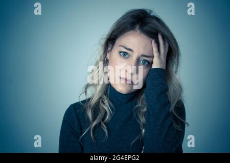 Porträt einer jungen attraktiven kaukasischen Frau, die an Depressionen, Stress und Angst leidet. Traurige und einsame Frau, die weint, sich deprimiert fühlt, verzweifelt ist Stockfoto