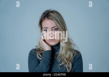 Porträt einer jungen attraktiven kaukasischen Frau, die an Depressionen, Stress und Angst leidet. Traurige und einsame Frau, die weint, sich deprimiert fühlt, verzweifelt ist Stockfoto