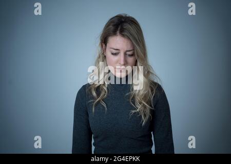 Porträt einer jungen attraktiven kaukasischen Frau, die an Depressionen, Stress und Angst leidet. Traurige und einsame Frau, die weint, sich deprimiert fühlt, verzweifelt ist Stockfoto