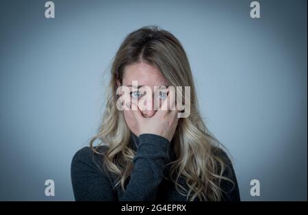 Porträt einer jungen attraktiven kaukasischen Frau, die an Depressionen, Stress und Angst leidet. Traurige und einsame Frau, die weint, sich deprimiert fühlt, verzweifelt ist Stockfoto