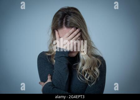 Porträt einer jungen attraktiven kaukasischen Frau, die an Depressionen, Stress und Angst leidet. Traurige und einsame Frau, die weint, sich deprimiert fühlt, verzweifelt ist Stockfoto