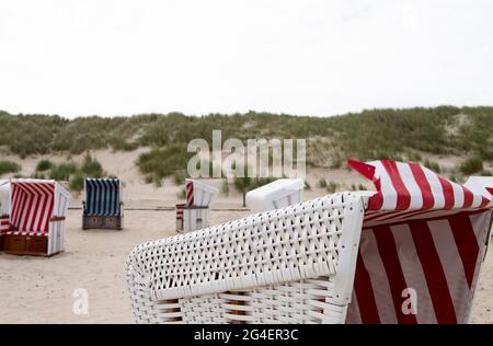 Das Foto zeigt einige Strandliegen auf der Nordseeinsel Baltrum mit bewölktem Himmel Stockfoto