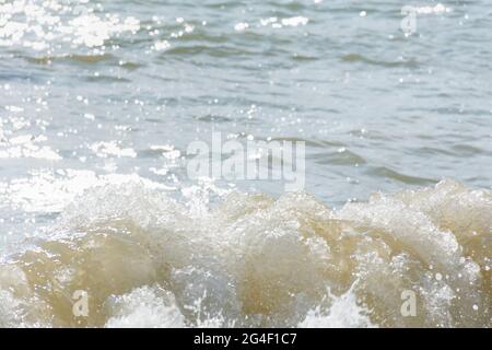 Silbernes Meer glitzernden Hintergrund. Minimalistische sommerliche Textur in Grau- und Beigetönen. Mittags heißer Tag. Die helle Sonne spiegelt sich in den Wellen wider. N Stockfoto