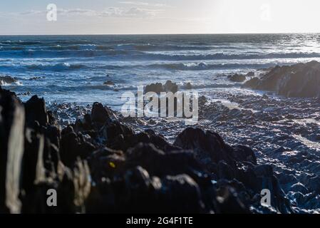 Abends fällt Licht auf die Felsen von Woolacombe, Devon Stockfoto
