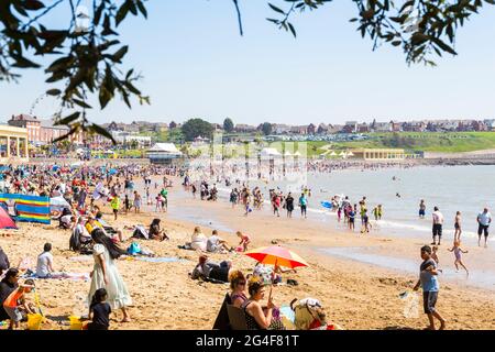 An einem sonnigen Frühlingsfeiertag ist der Strand des Seebadeorts Barry Island voll. Stockfoto