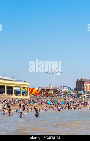 An einem sonnigen Frühlingsfeiertag ist der Strand des Seebadeorts Barry Island voll. Stockfoto