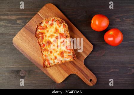 Blick von oben auf frisch gebackene hausgemachte Pizza Toast mit zwei frischen Tomaten Stockfoto