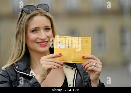 Die junge Frau zeigt stolz ihren Impfpass nach der ersten und zweiten Impfung gegen Covid-19, SARS-CoV-2, Corona-Krise, Stuttgart Stockfoto