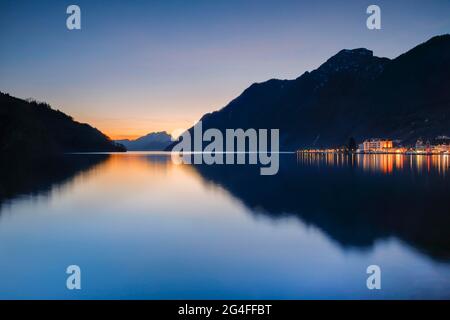 Beleuchtete Uferpromenade von Brunnen und Blick über den Vierwaldstättersee bei Sonnenuntergang mit dem Pilatus im Hintergrund Stockfoto