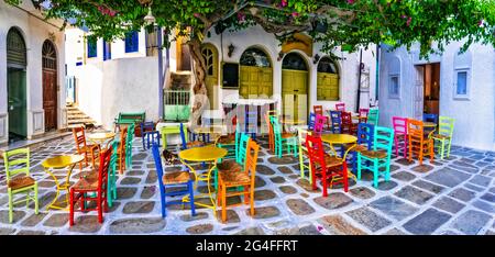 Traditionelle griechische Tavernen auf den Straßen. Insel iOS, Altstadt Chora. Restaurant mit bunten, typischen Stühlen. Kykladen, Griechenland Stockfoto