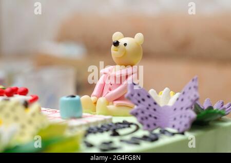 Rosafarbene Bärenfigur aus Zuckerpaste oder Fondant Icing, eine essbare Dekoration auf einer Torte aus der Nähe Stockfoto
